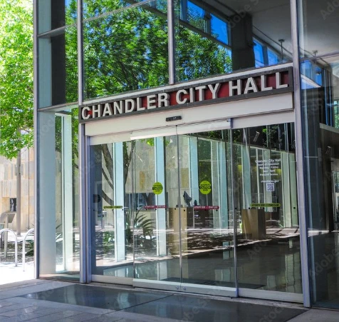 Main entrance of Chandler City Hall featuring a glass facade and bold red signage in Chandler, Arizona.