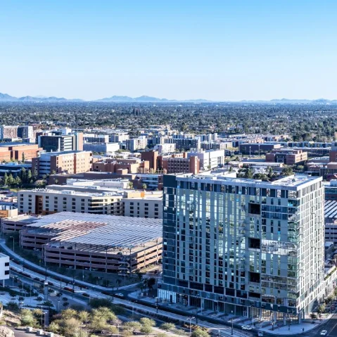 Aerial view of Arizona State University buildings, residence halls, and parking structures in Tempe, Arizona.